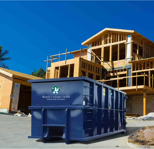 Stacked cardboard boxes on a recycling bin for commercial waste disposal services.